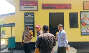 Haji Ramang Ishaka (topi merah) didampingi Kuasa hukumnya, Gabriel Kou (belakang), saat keluar dari ruang Unit Tipidum Polres Mabar, Kamis (30/4/2026) siang. [Foto Rino/GBRNews.id]