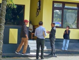 Haji Ramang Ishaka (topi merah) didampingi Kuasa hukumnya, Gabriel Kou (belakang), saat kembali masuk ke dalam ruang pemeriksaan Unit Tipidum Polres Mabar, Kamis (30/4/2026) siang. [Foto Rino/GBRNews.id]